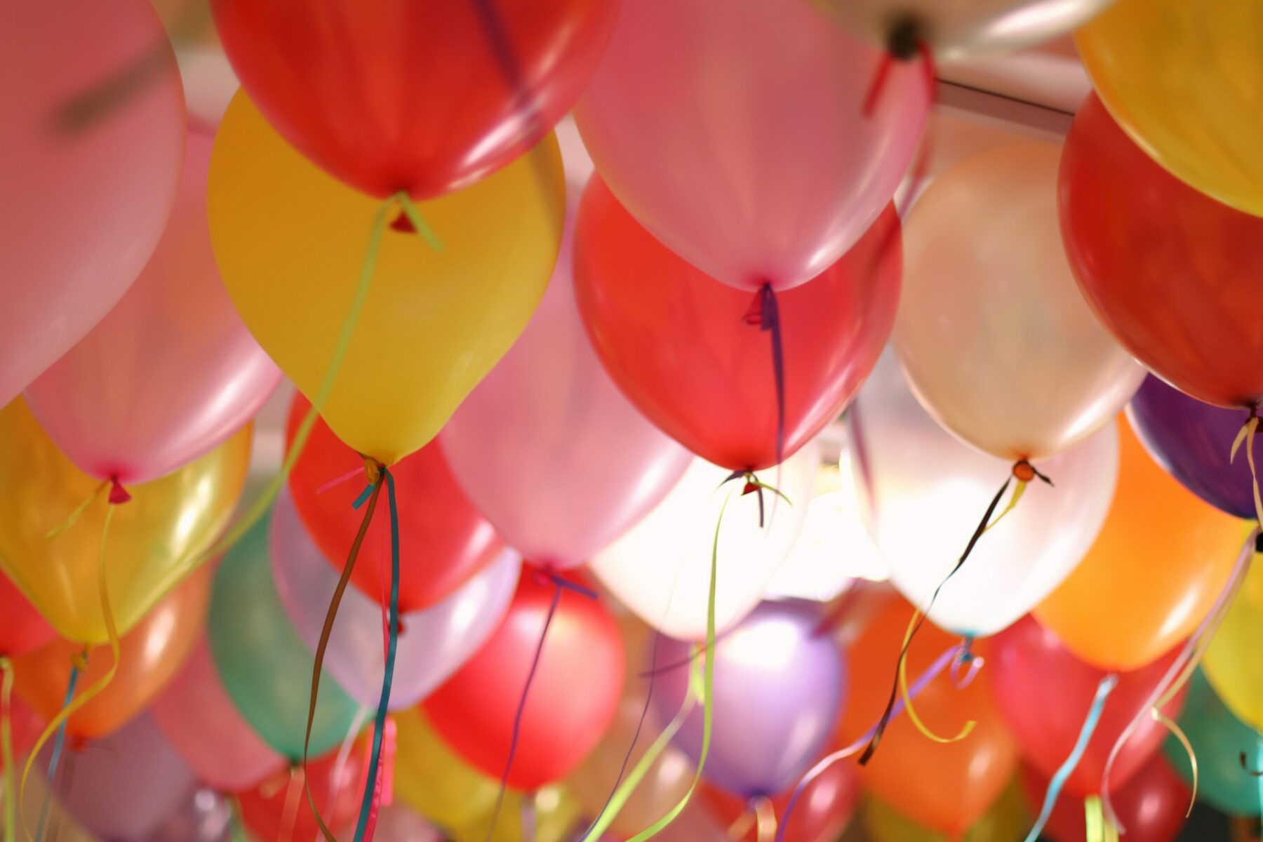 Dozens of colorful, festive balloons on strings