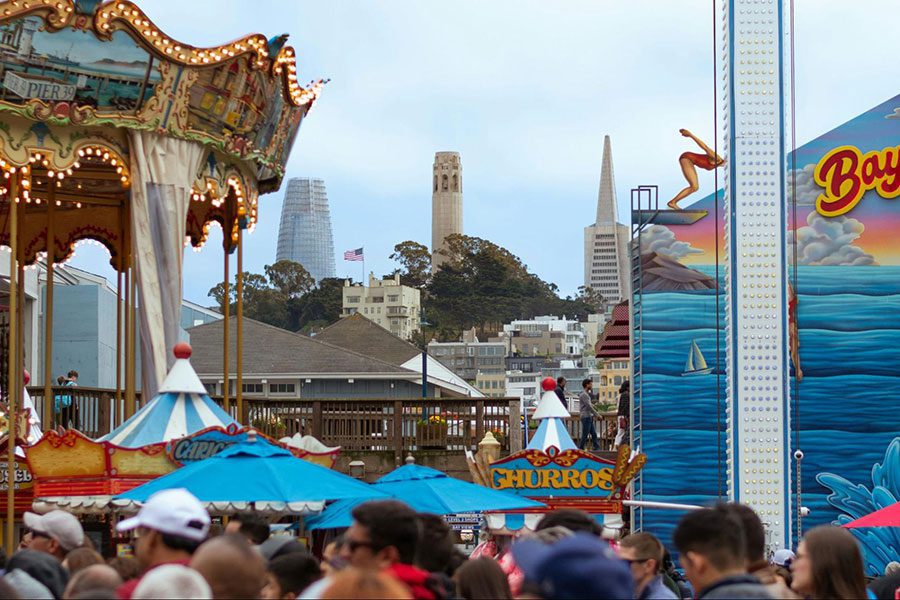 Photo of a carousel on San Francisco’s Pier 39 with the city skyline in the background.