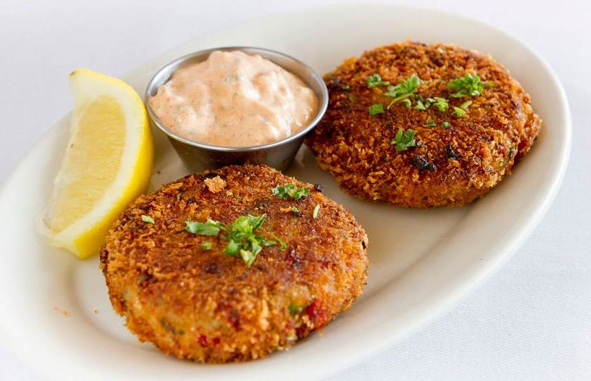 Crab cakes served on a white plate.