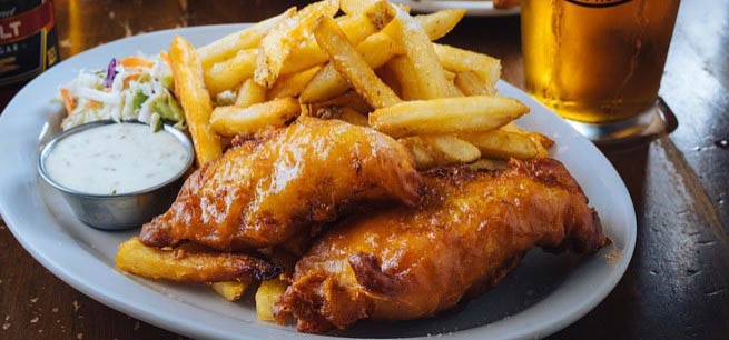 Fish and chips served with a beer.