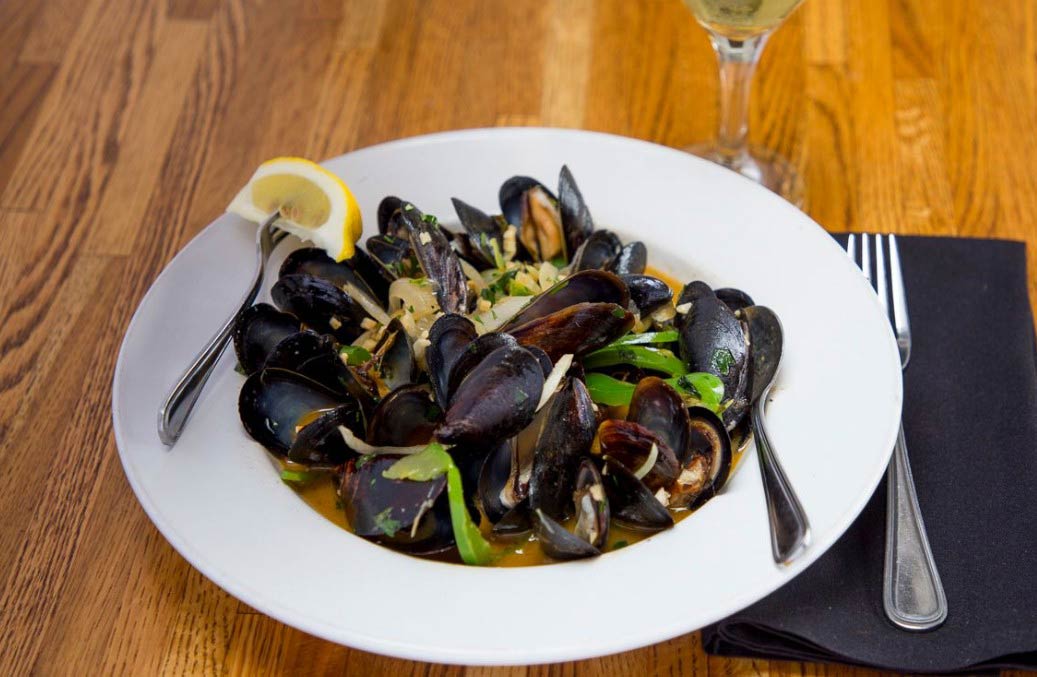 Steamed mussels served with a lemon.